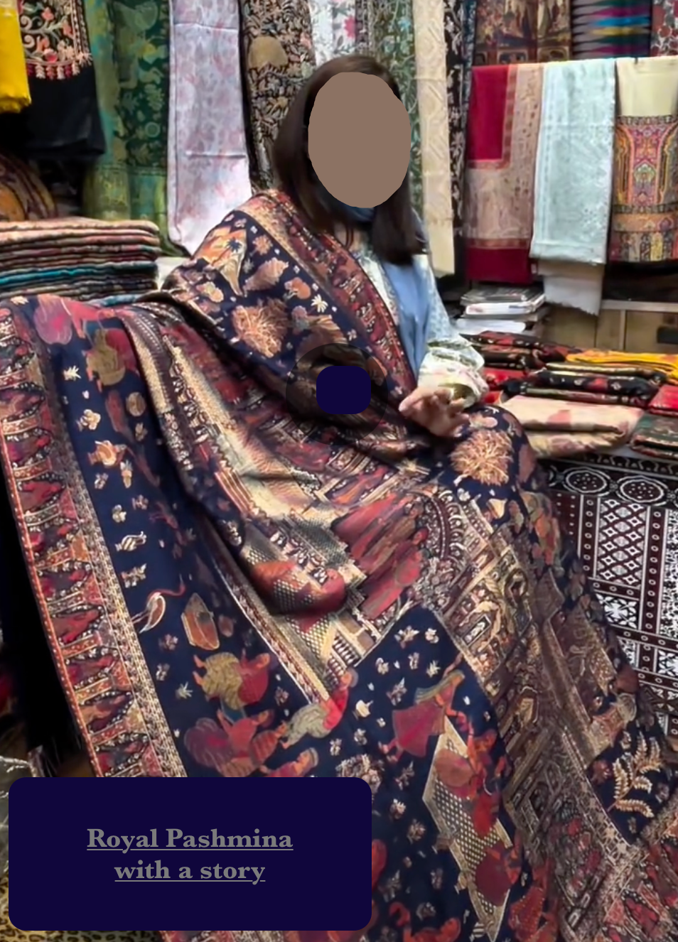 Person holding a patterned pashmina with text 'Royal Pashmina with a story' in a store setting.