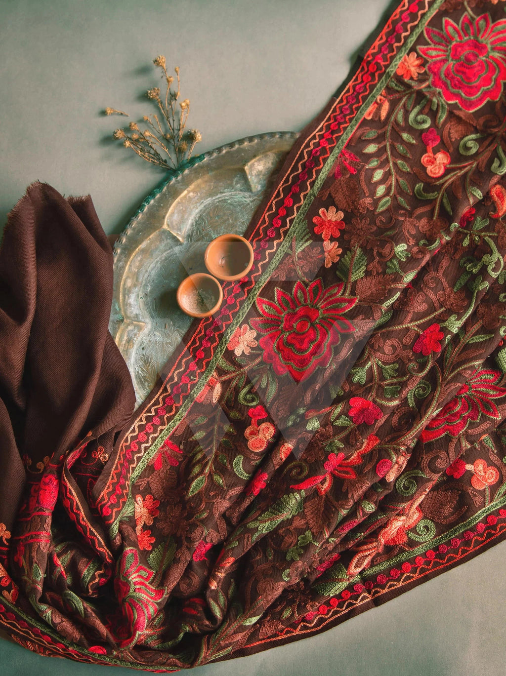 Embroidered fabric with floral patterns on a textured surface, featuring the brand 'weavecore'.