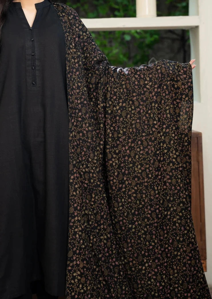 Woman holding a black and brown patterned fabric in front of a shelf with decorative items.