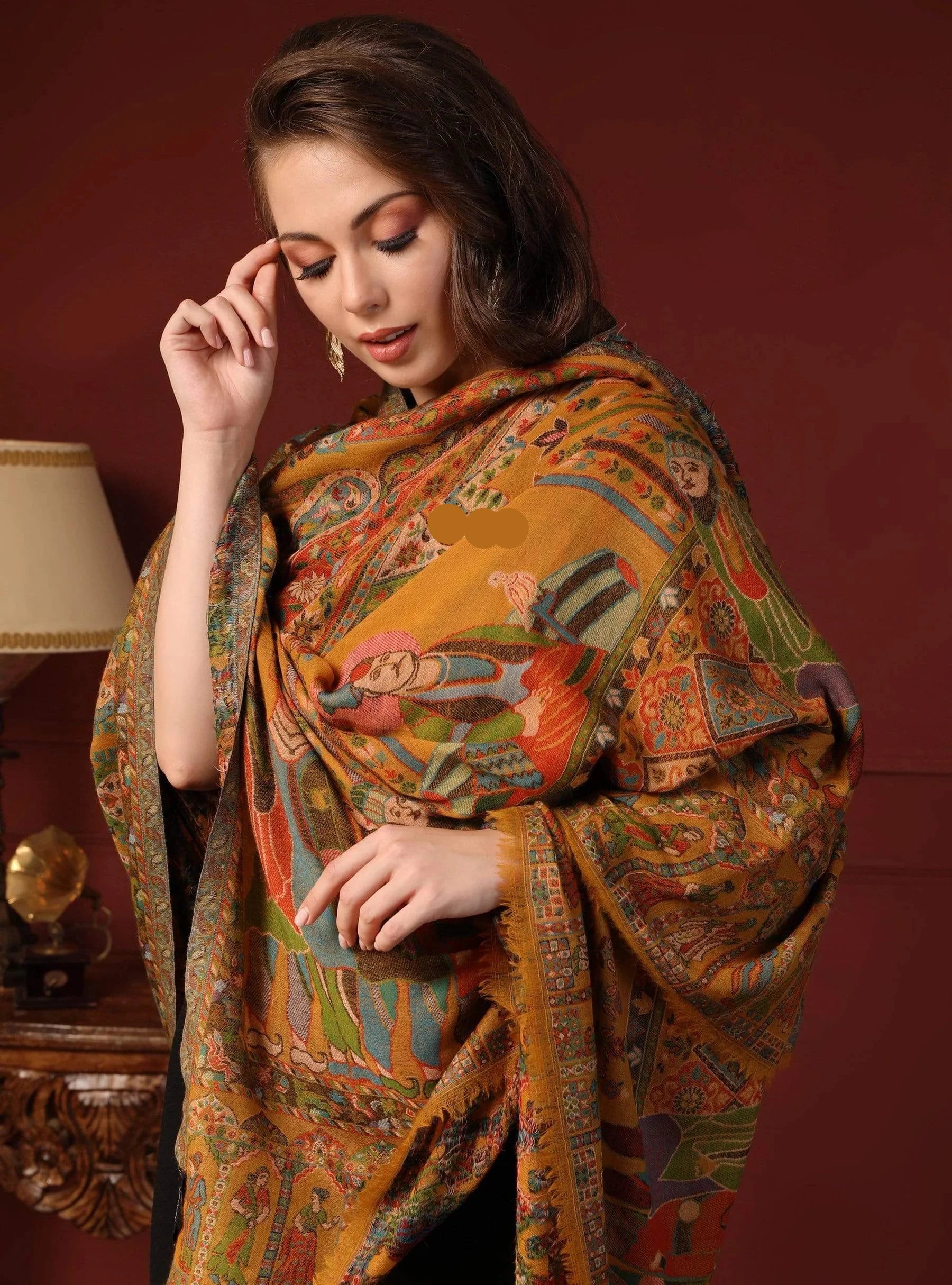 Woman wearing a colorful patterned shawl against a red background
